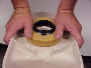 wax ring being installed on a toilet