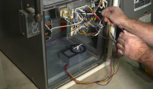 man installing ionizer in ac system